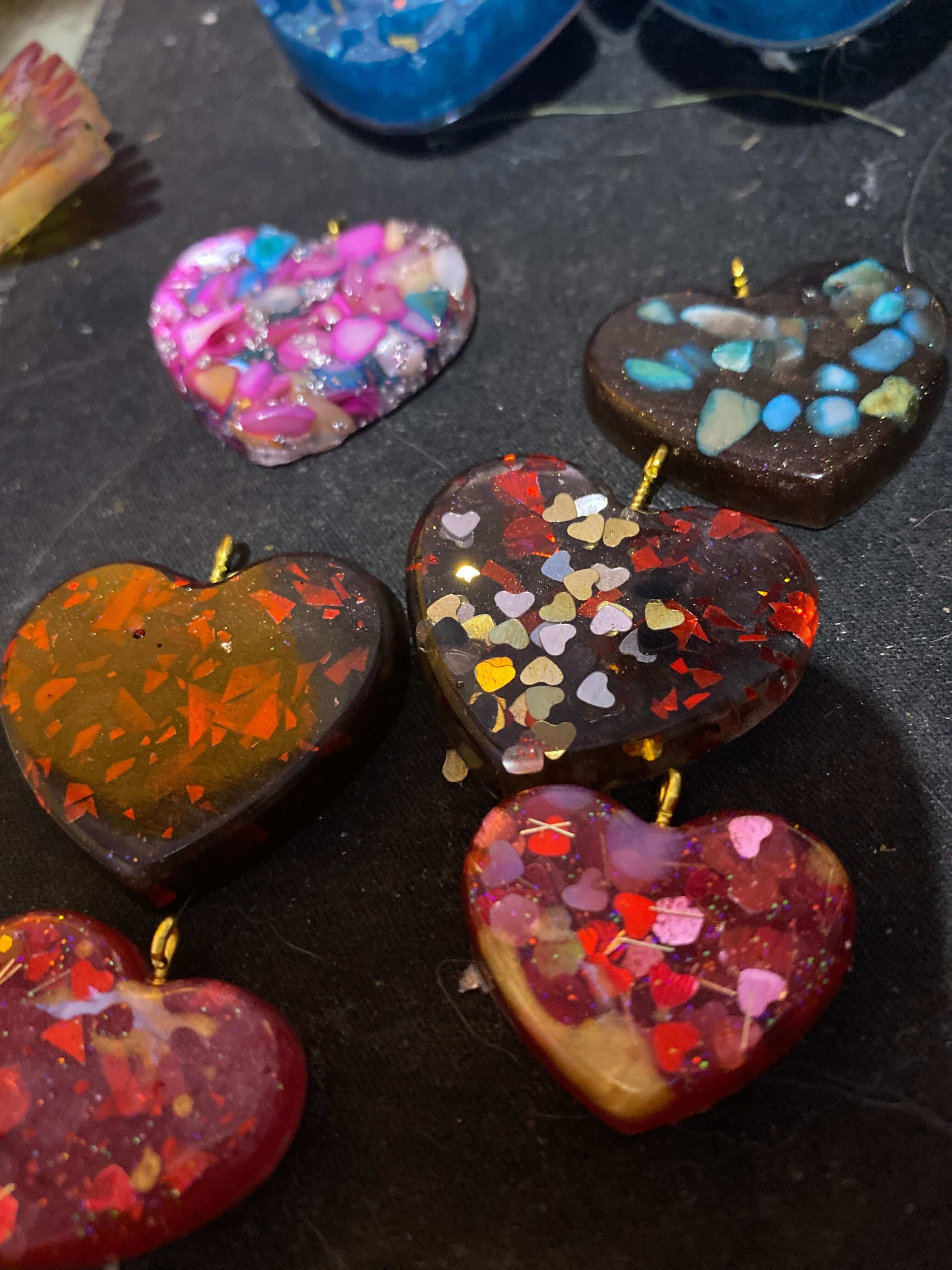 Colorful love heart pendant and earring set featuring various heart shapes with glitter and resin details.