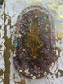 Alice in Wonderland trinket tray with a gold figure, purple resin, and colorful glitter accents.