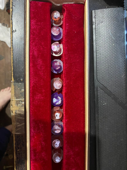 Unique chef buttons displayed in a velvet-lined box, featuring various colors and intricate designs.