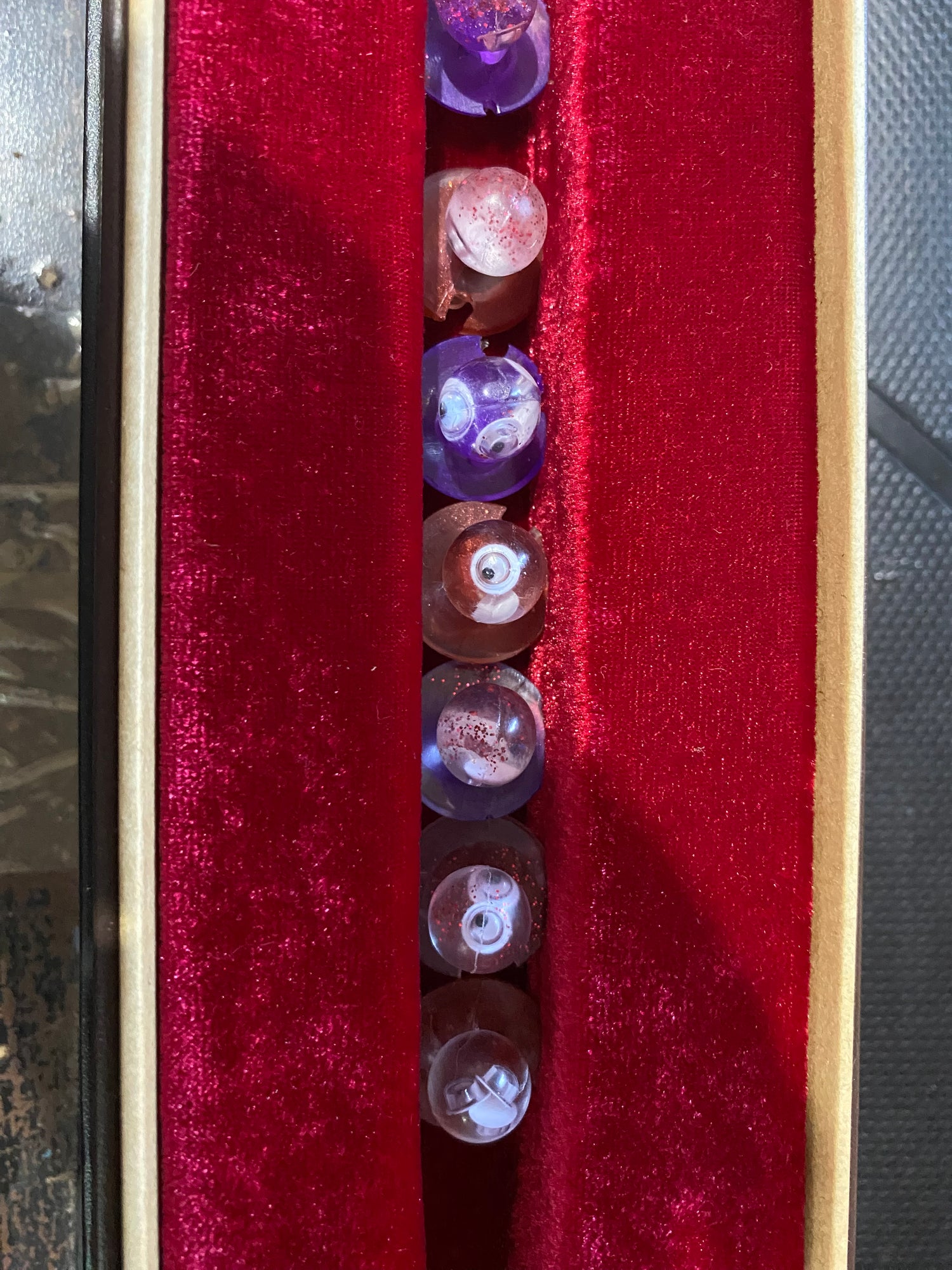 Unique chef buttons displayed in a velvet-lined box, featuring various colors and intricate designs.