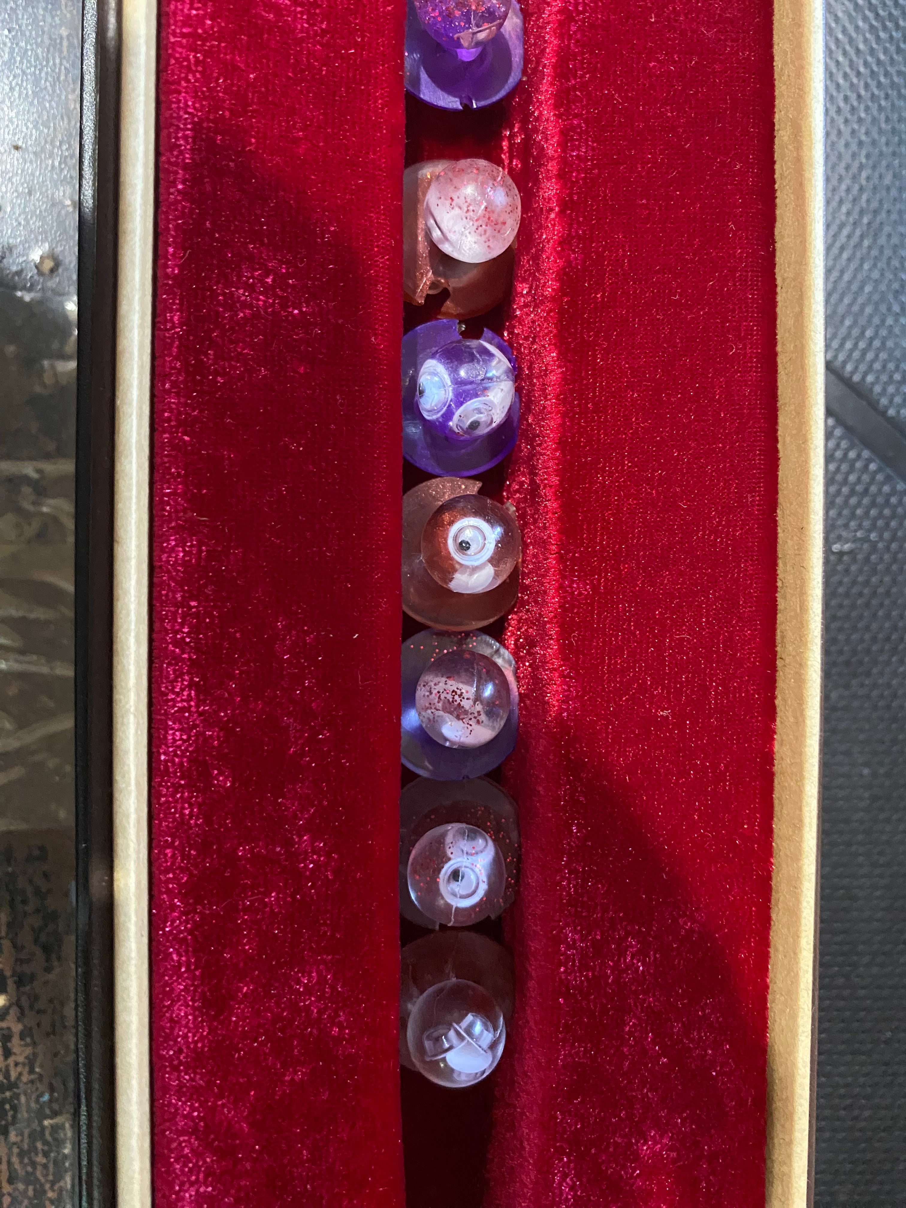 Unique chef buttons displayed in a velvet-lined box, featuring various colors and intricate designs.