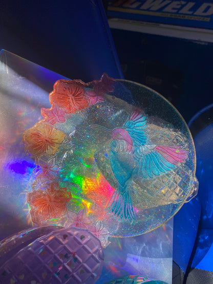 Heart-shaped trinket box with a hummingbird and colorful floral designs, featuring a glittery, iridescent surface.