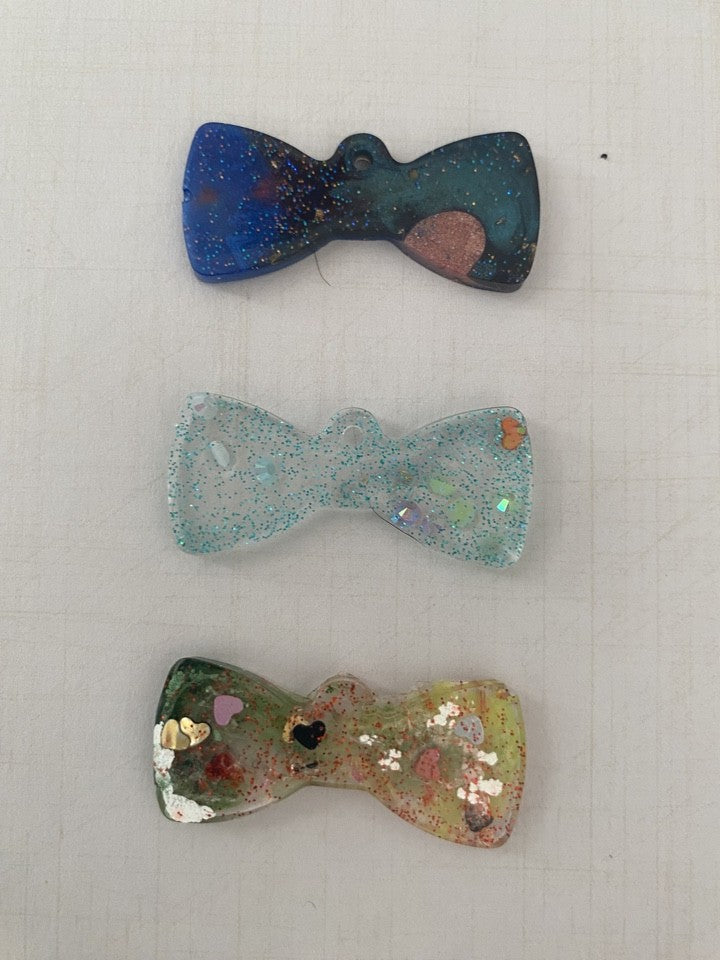 Personalised Pet ID tags by Piggymac Creations, bow-shaped multicolour speckled tags for pets.
