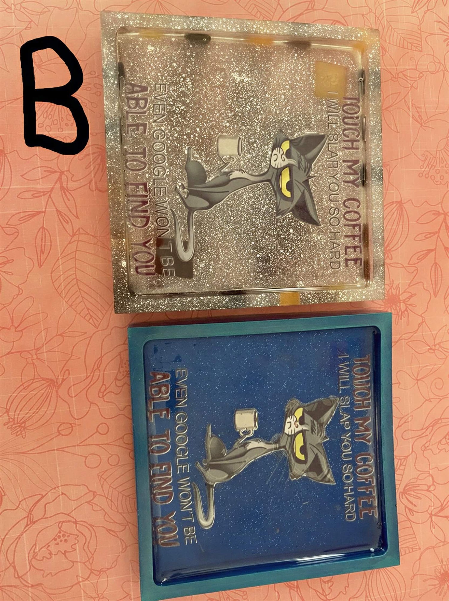 Two rectangular coasters with humorous text, one in blue and one with a glittery finish, featuring cartoon characters.