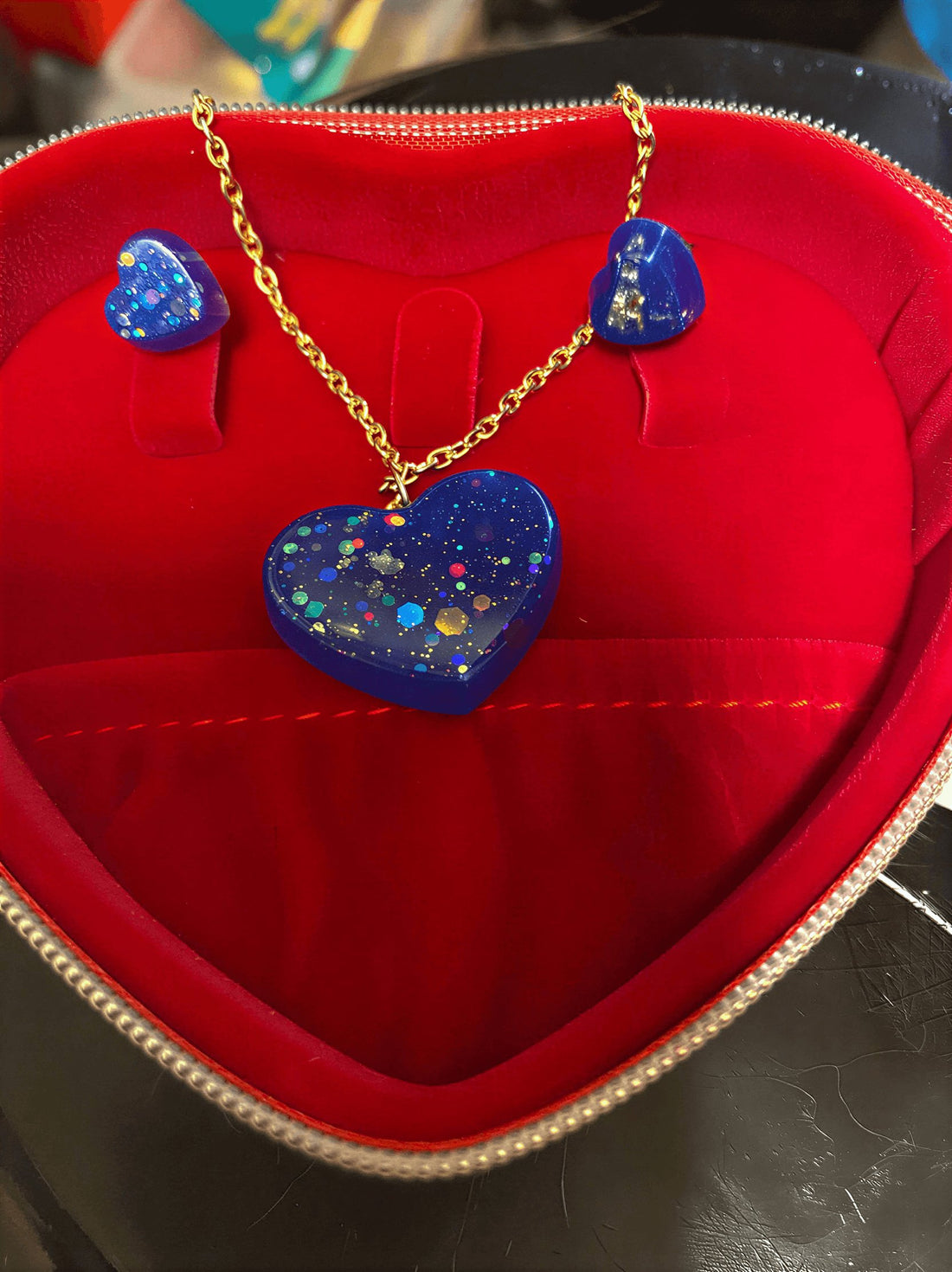 love heart pendant and earring set featuring a blue heart pendant and matching earrings in a red jewelry box.