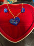 love heart pendant and earring set featuring a blue heart pendant and matching earrings in a red jewelry box.